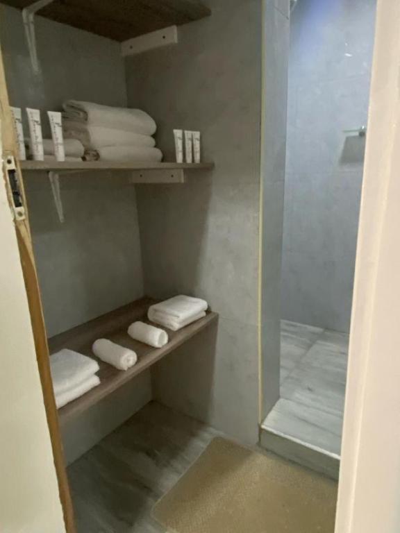 a walk in shower with towels and a glass door at White House Residences in Lusaka