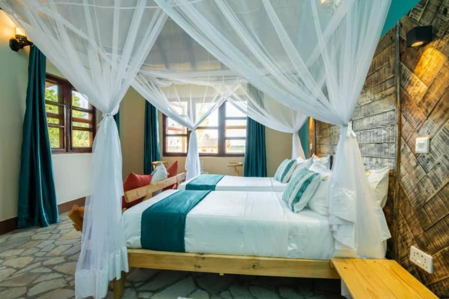 a bedroom with a bed with a canopy at Nile treatz hotel in Pakwach East