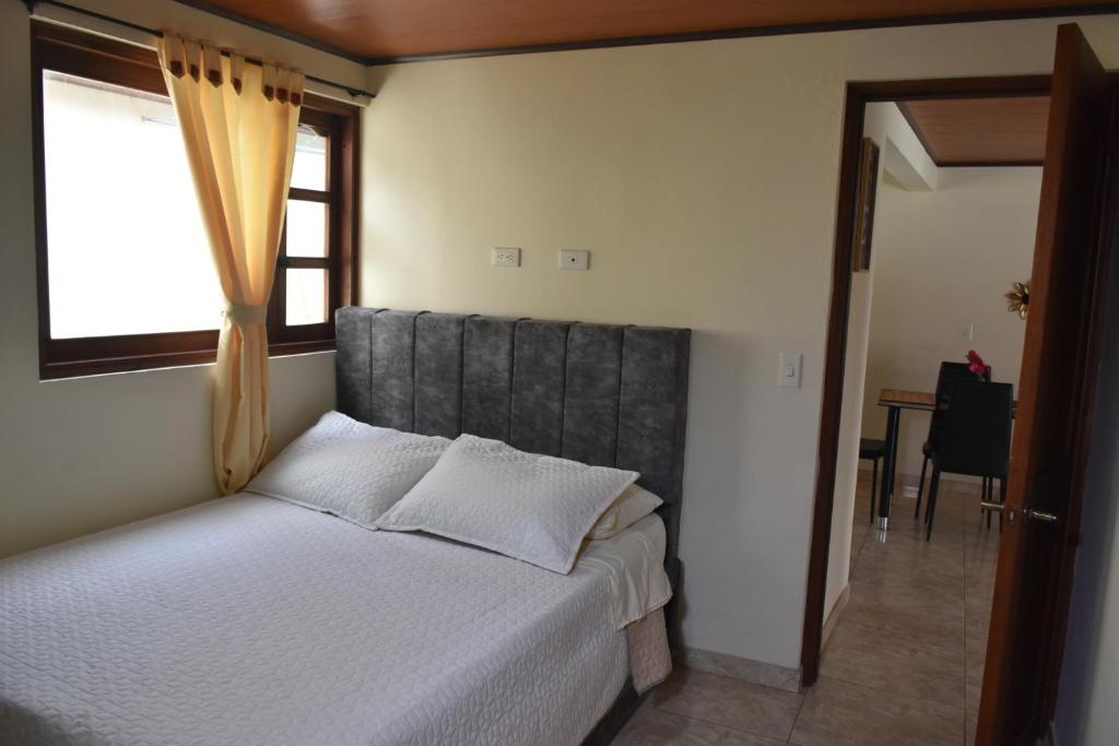 a bedroom with a bed with a large window at Confortable apartamento cerca de la plaza principal in Villa de Leyva