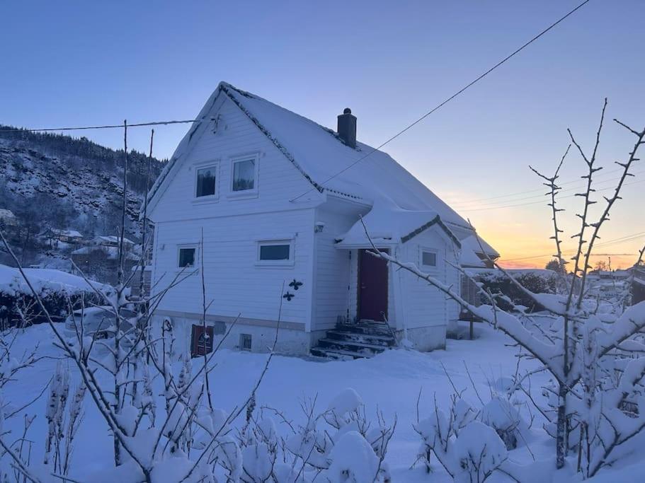 a white house with snow on the ground at Stort, koselig hus i naturområde in Bergen