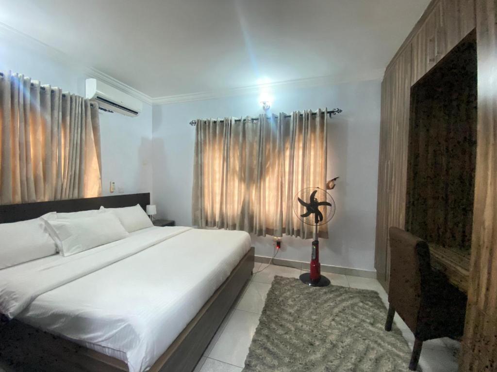 ein Schlafzimmer mit einem großen weißen Bett und einem Fenster in der Unterkunft Amazing Grace Apartment in Ikeja