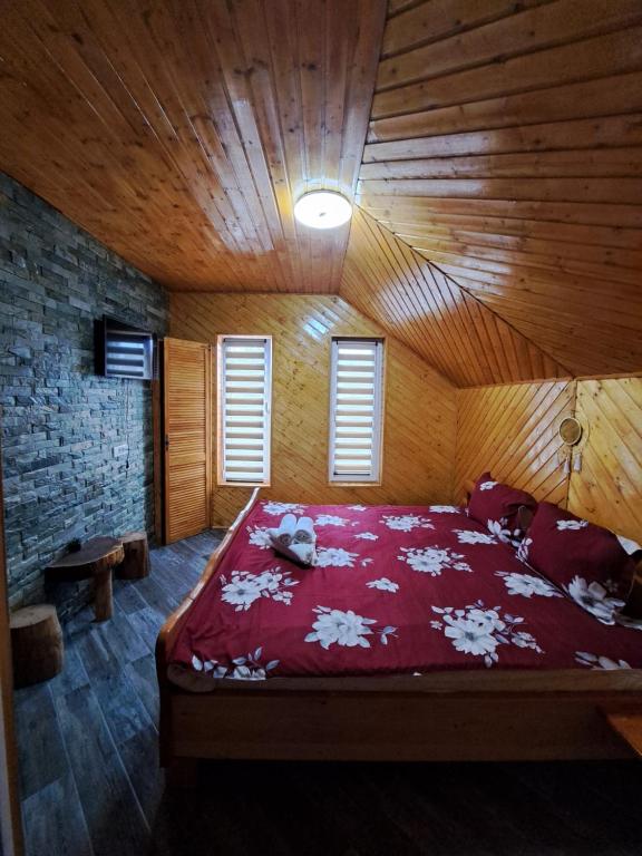 um quarto com uma cama grande num quarto de madeira em Pensiunea Casa Amy em Gladna Romînă