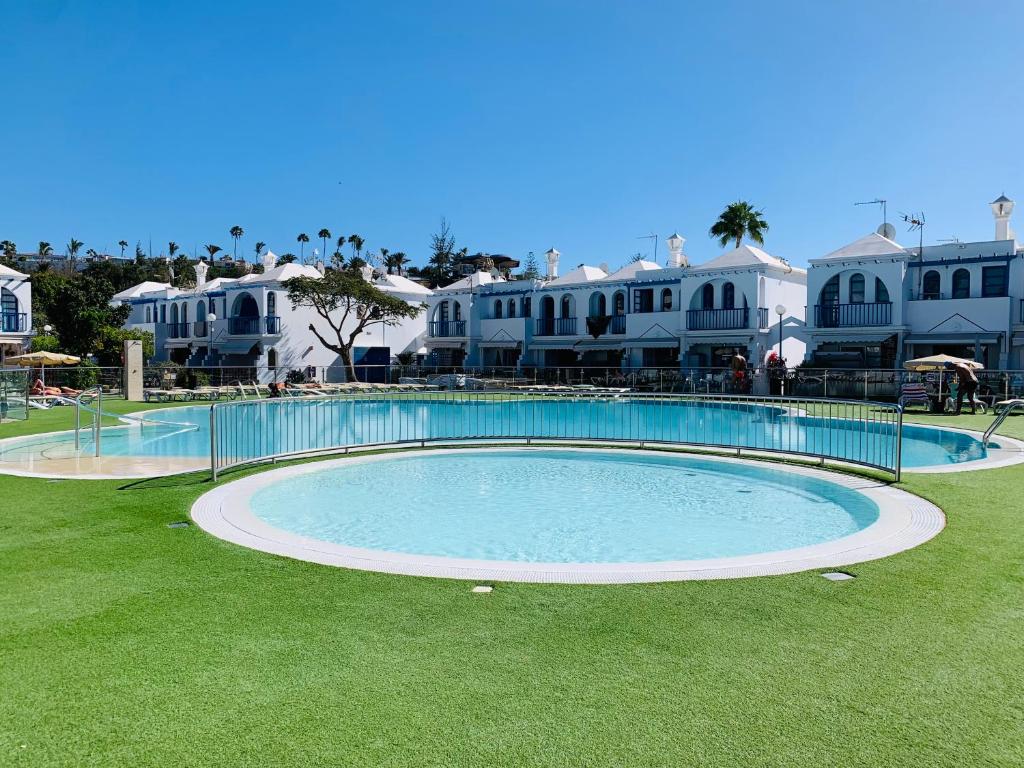 uma grande piscina em frente a algumas casas em Bungalow Terrace&Pool near the Beach em Maspalomas