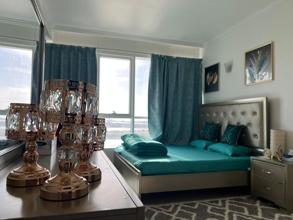 - une chambre avec un lit et une fenêtre avec des oreillers bleus dans l'établissement Burj Al saadah Al mamzar sharjah, à Charjah