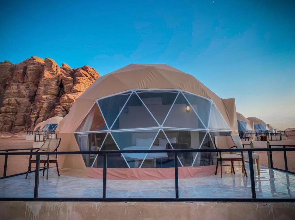a dome tent with chairs in the desert at WADi RUM MAGIC CAMP in Wadi Rum