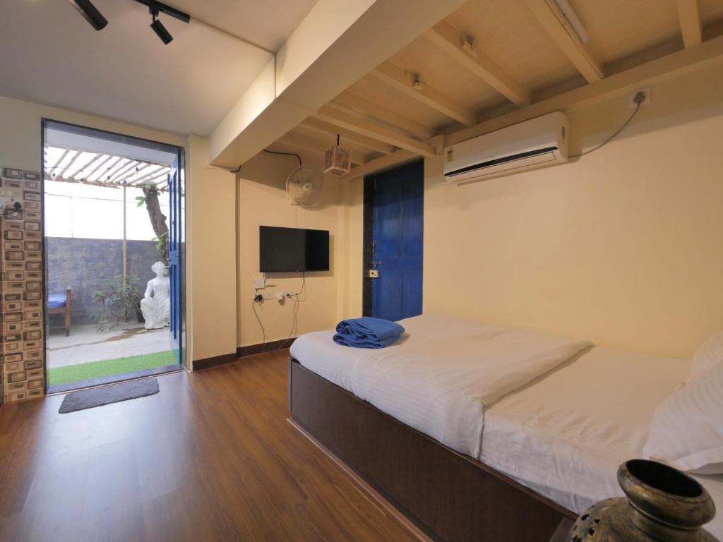 a bedroom with a large bed and a tv at Ranger - Bandra West in Mumbai