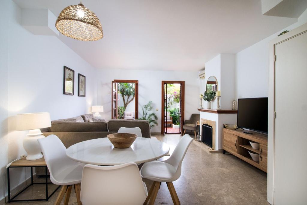 ein Wohnzimmer mit einem Tisch, Stühlen und einem Sofa in der Unterkunft Villacana Community Family Beach Resort in Estepona