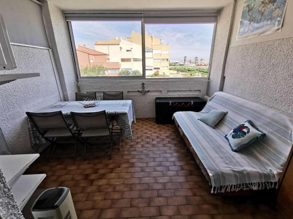 une chambre avec un canapé, une table et une fenêtre dans l'établissement Résidence Les Nefs Des Sables - STUDIO 4 PERSONNES 5 couchages PORT LEUCATE. Réf: 2NEF_24K4 MAE-6884, à Port-Leucate
