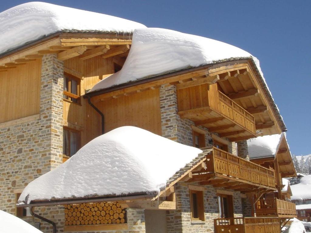 Cabaña de madera con nieve en el techo en Chalet Lè Lodzé - Pieds des pistes, en La Rosière