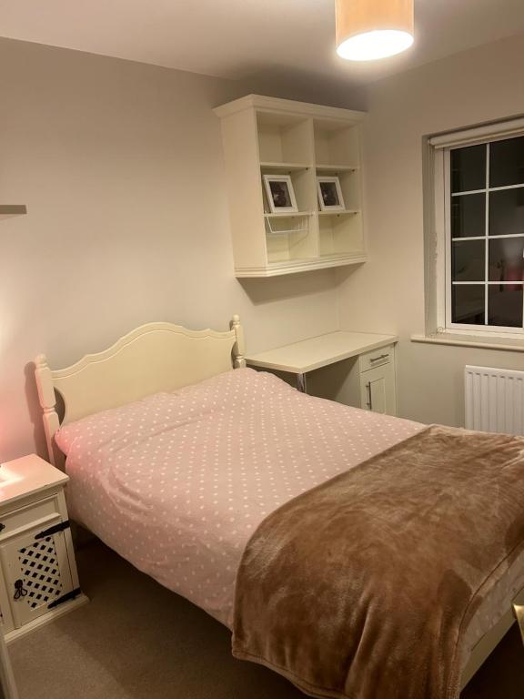 a bedroom with a bed and a desk and a window at Valley view in Gort