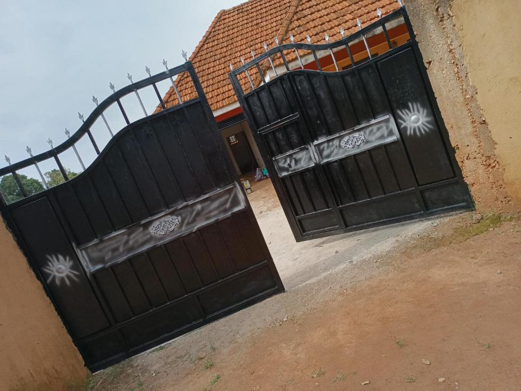 a pair of gates in front of a house at foxxies guest house in Buloba
