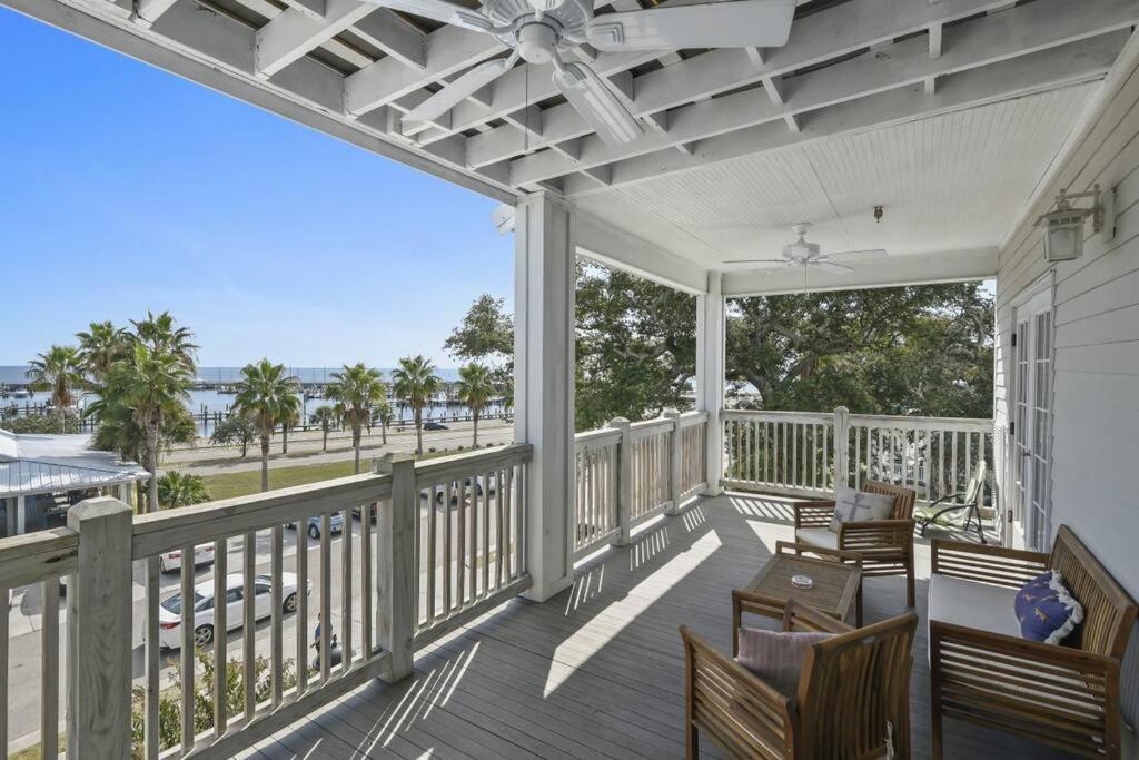 a screened porch with chairs and a table and a view of the ocean at Hotel Pass Christian King Suite 301 in Pass Christian