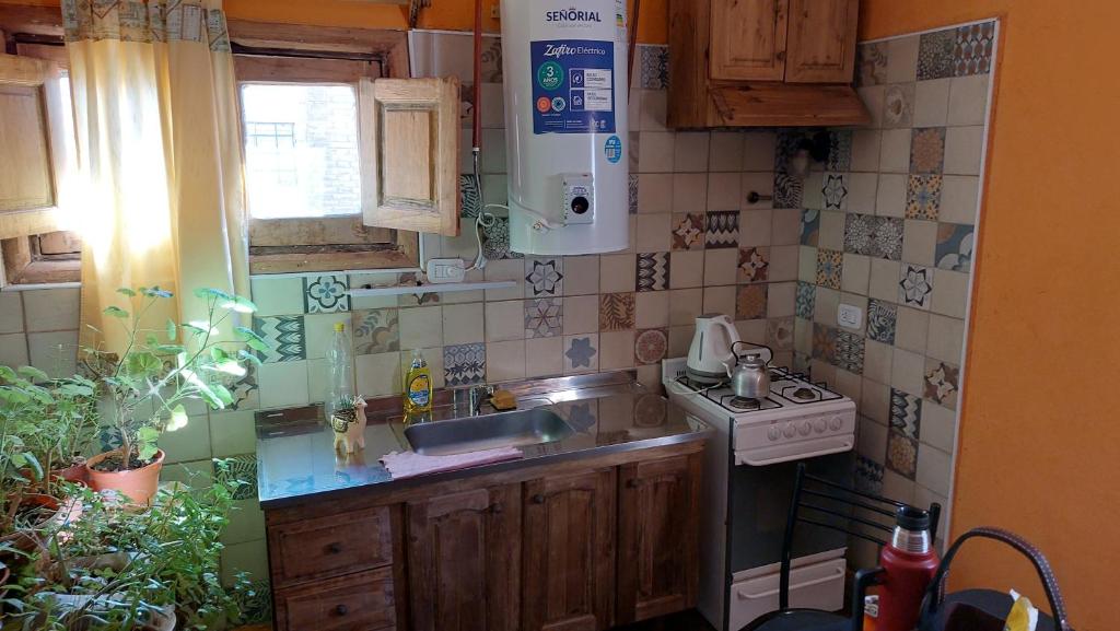 a small kitchen with a sink and a stove at Como en casa in Uspallata