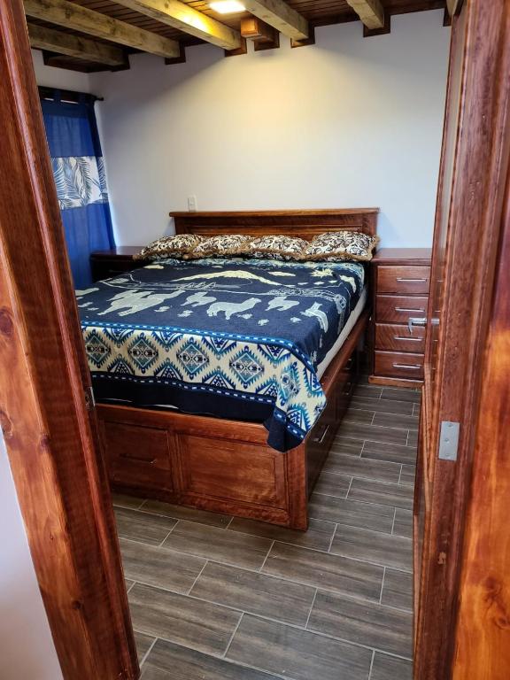 a bedroom with a wooden bed in a room at Casita Luna de Miel in Nabón