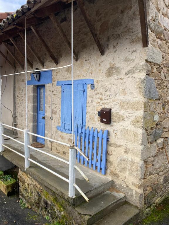 une porte bleue sur le côté d'un bâtiment en pierre dans l'établissement maison de prescillia et frederic, à Boisset