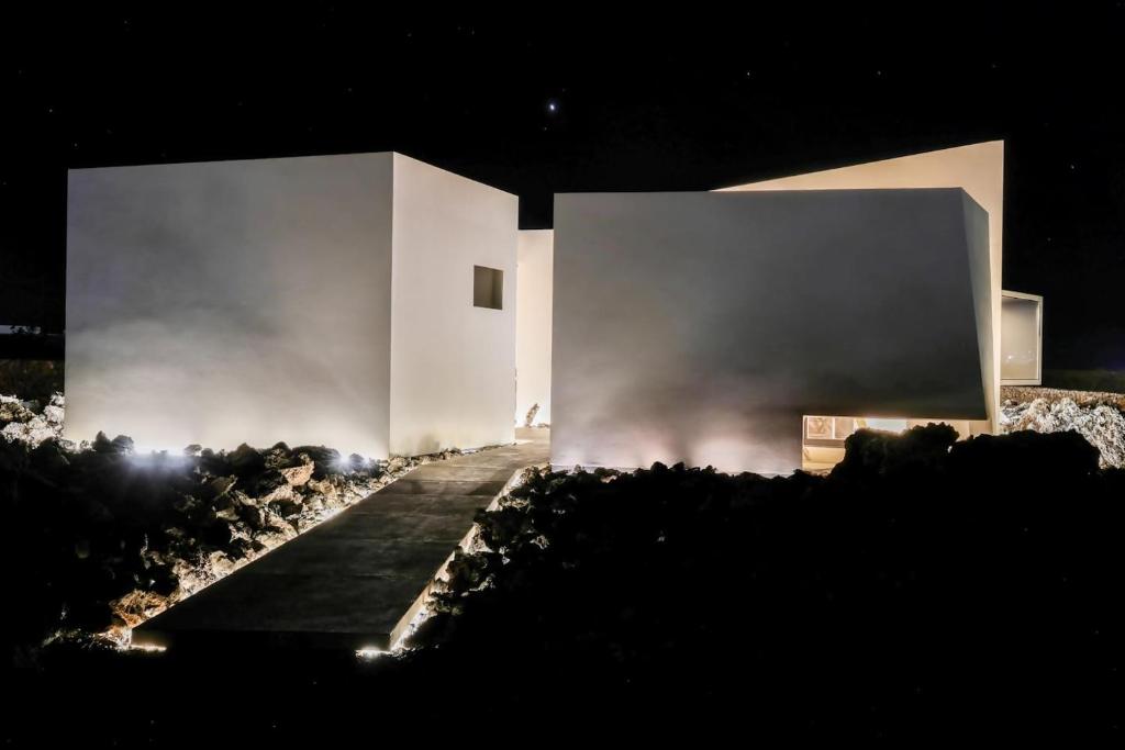 Ein weißes Gebäude in der Nacht mit Rauch aus dem Gebäude in der Unterkunft Luxury Villa Vulcano Lajares in Lajares