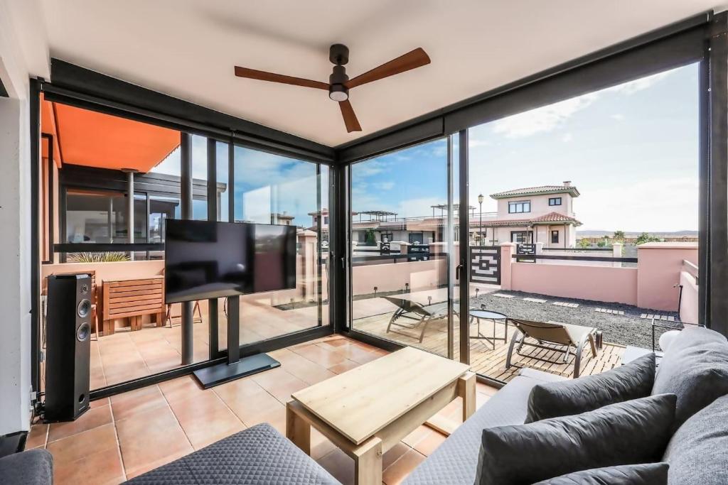 a living room with a couch and a flat screen tv at HolaOla HighClass Townhouse in Lajares
