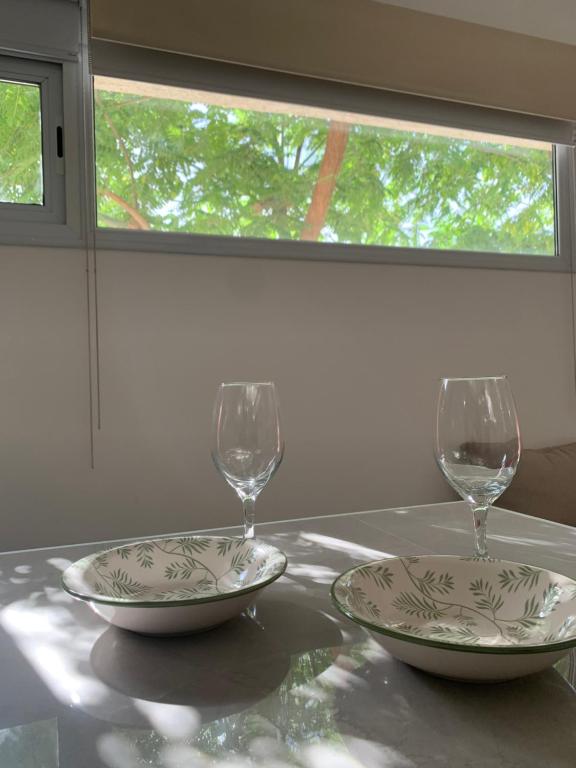 deux verres et deux assiettes sur une table dans l'établissement Las Tipas mini loft Cafayate, à Cafayate