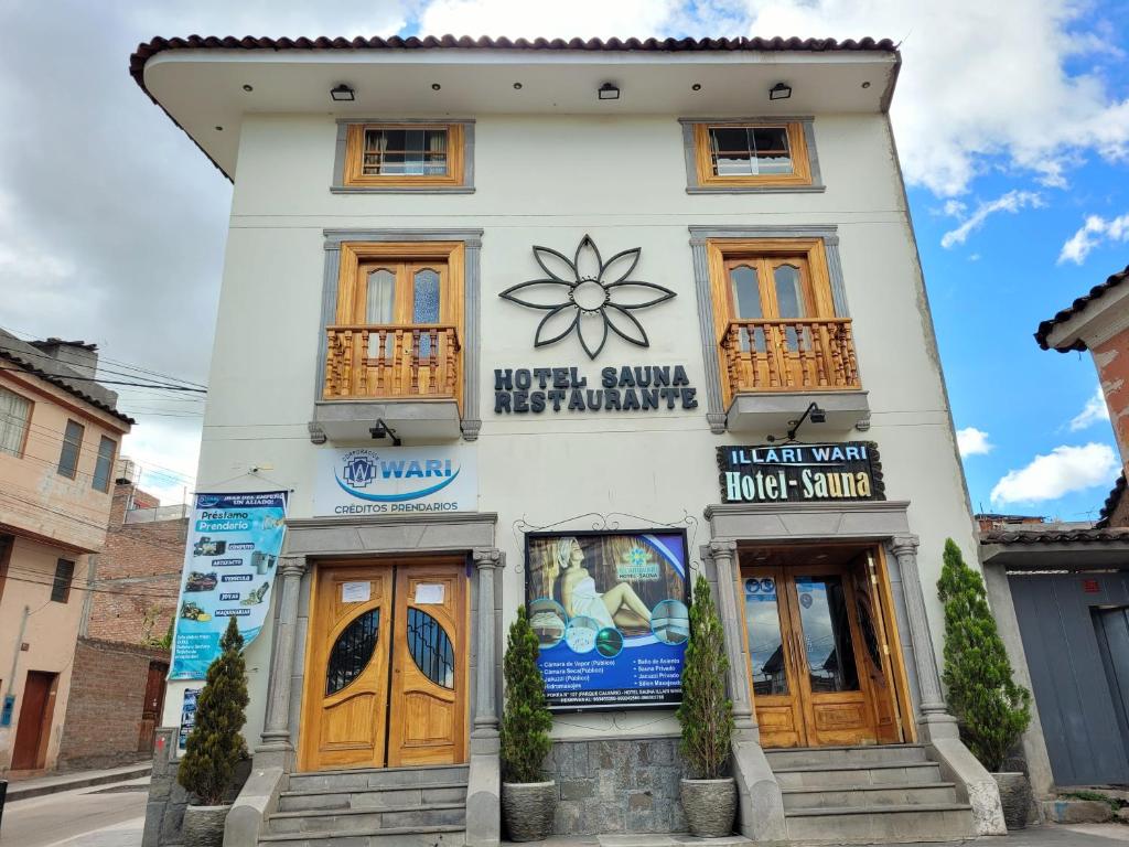 um edifício branco com portas de madeira numa rua em Illari Wari II-Hotel Sauna em Ayacucho