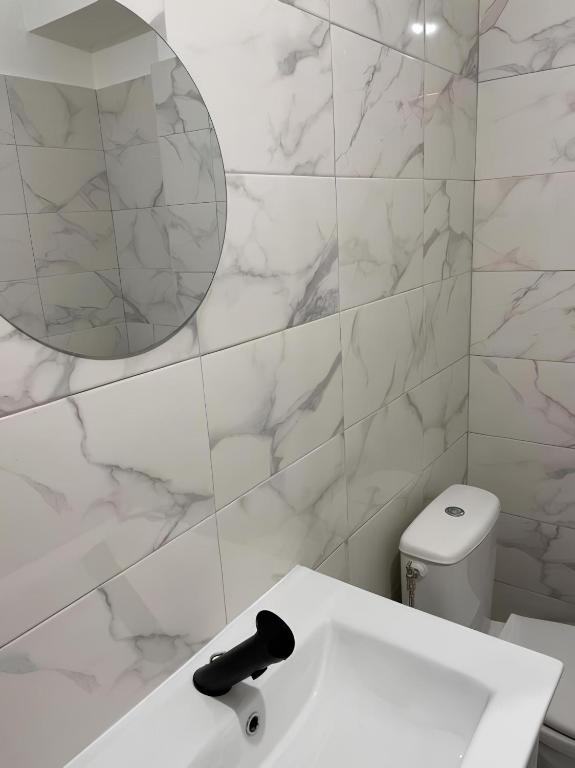 a white bathroom with a sink and a mirror at Studio 50 m de la mer - Centre - Vue mer partielle in Nice