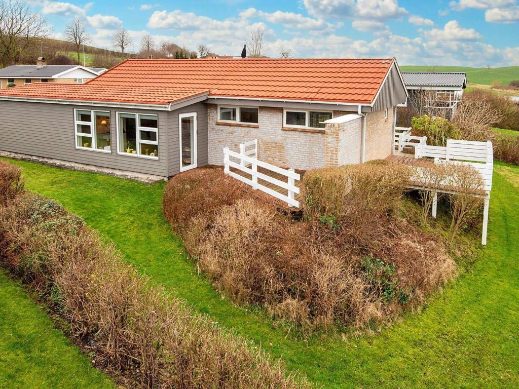 una pequeña casa con techo naranja en un patio en 6 person holiday home in Broager, en Broager