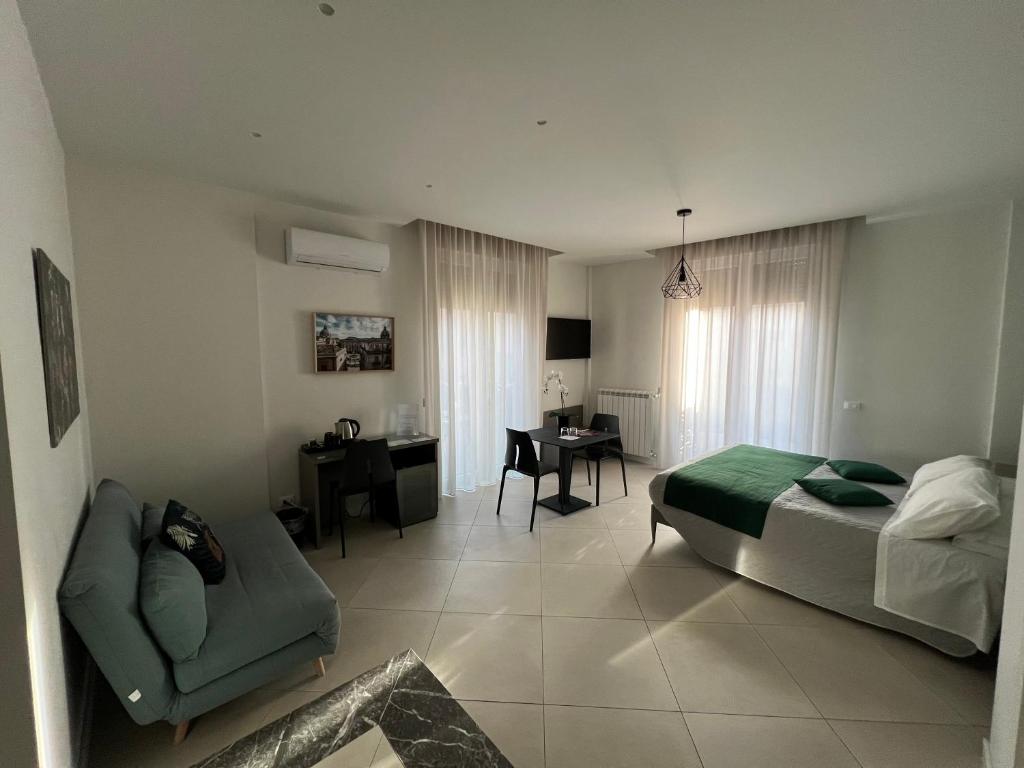 a bedroom with a bed and a chair and a desk at Maqueda Suites in Palermo