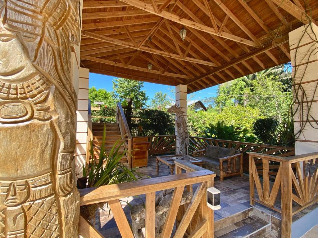 una terraza al aire libre con una talla de madera de aiki en Dream Valley Belize en Teakettle Village