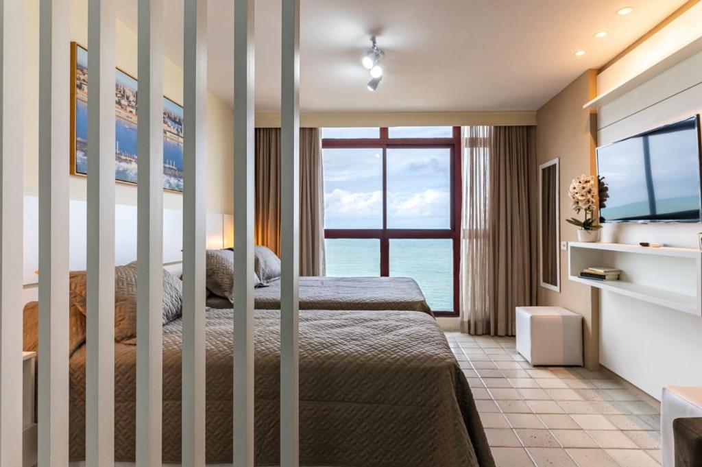 1 dormitorio con 2 camas y ventana grande en Golden Beach Flat Recife, en Recife