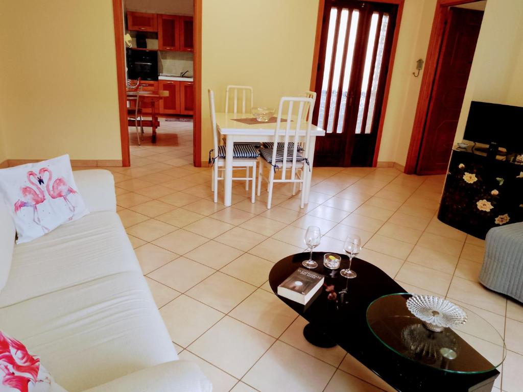 ein Wohnzimmer mit einem weißen Sofa und einem Tisch in der Unterkunft Il Fenicottero Rosa Casa Sanzio in Quartu SantʼElena