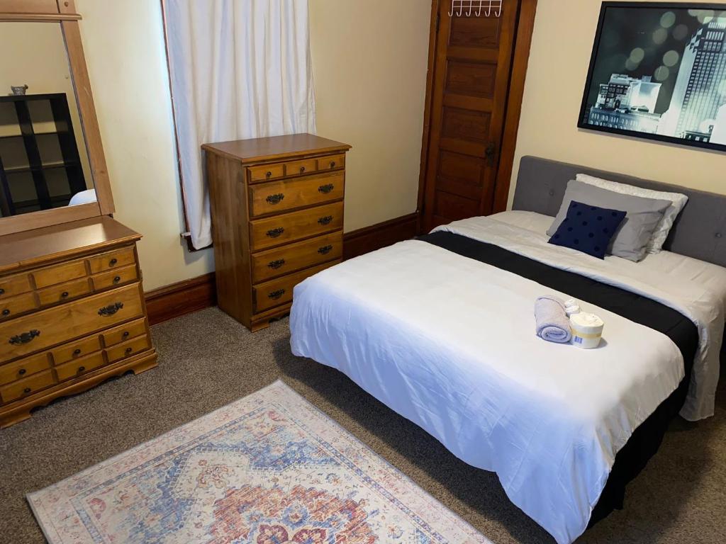 ein Schlafzimmer mit einem Bett und einer Kommode mit Schuhen drauf in der Unterkunft Hite Home in Akron