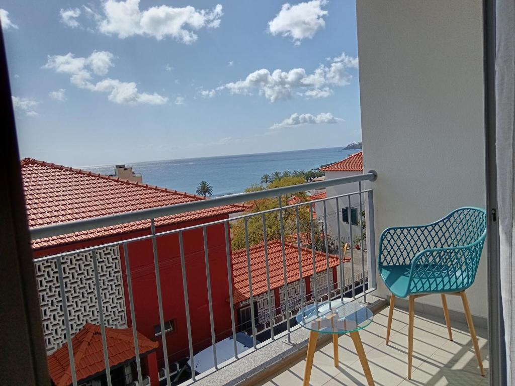 Un balcón con una silla y vistas al océano. en Casa da Vila, en Santa Cruz