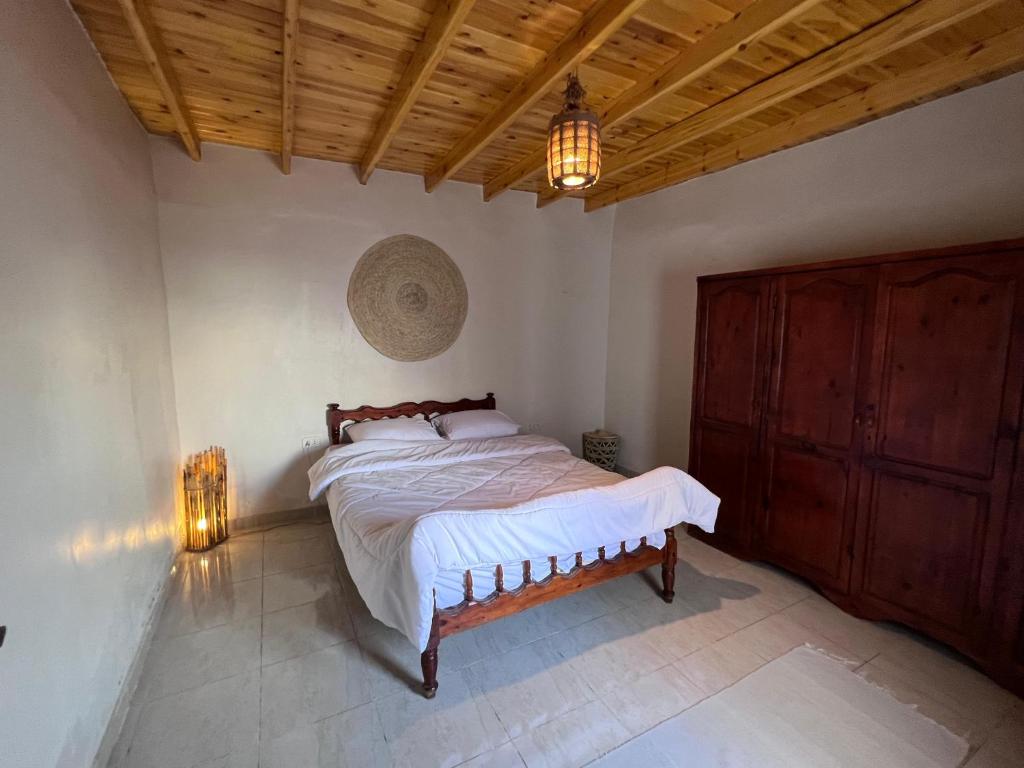 a bedroom with a bed and a wooden ceiling at Oro Guesthouse in Dahab