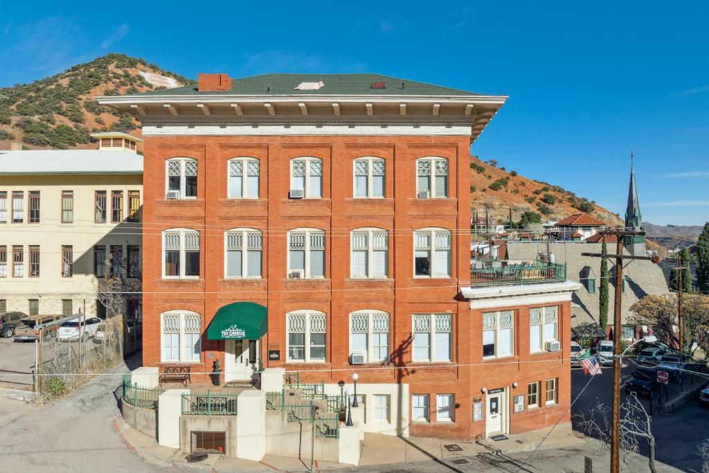 a large red brick building with a green awning at THE CARRICK in Bisbee