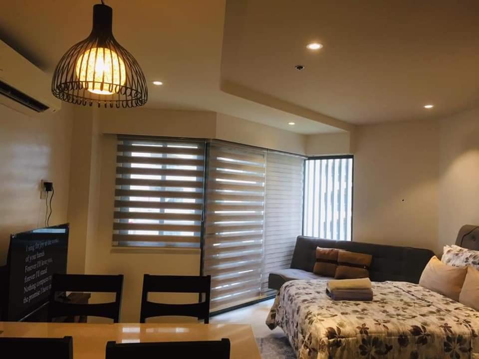 a bedroom with a bed and a couch and a table at Tambuli maribago seaside living and resort in Lapu Lapu City
