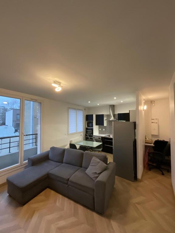 sala de estar con sofá y cocina en DUPLEIX PARISIEN, en Vanves