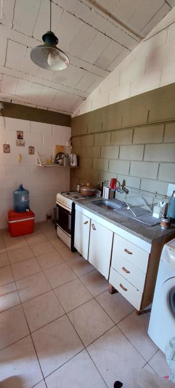 a kitchen with a sink and a stove in it at Habitación En La Casita de Marley in Villa Carlos Paz