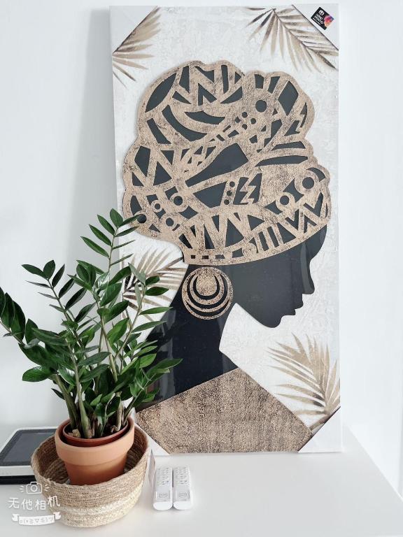 a potted plant sitting on a table next to a painting at San Eugenio in Adeje
