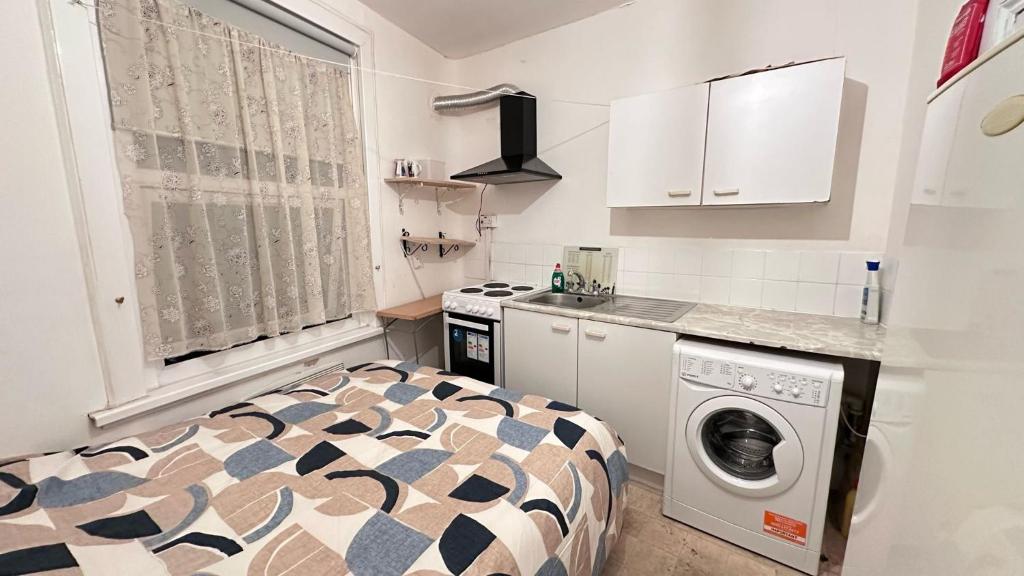 a small kitchen with a washer and dryer at Studios/ Bedsitter living unit -Ilford in Ilford