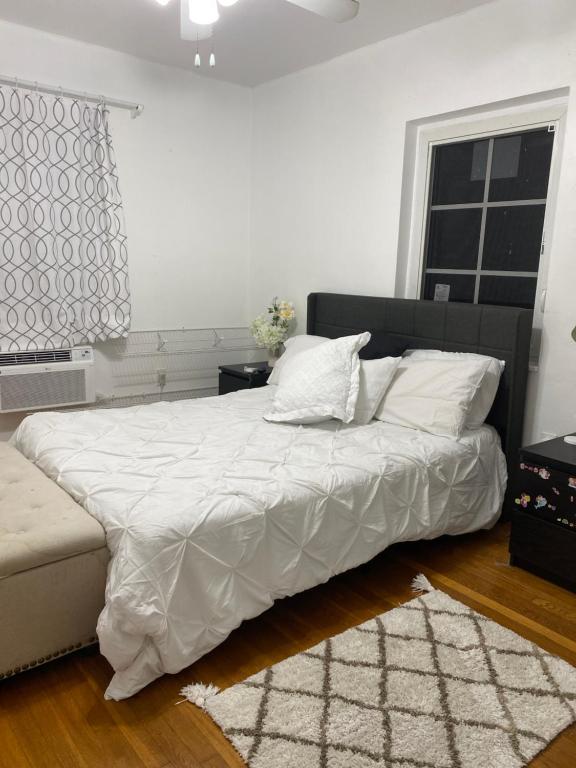 1 dormitorio con 1 cama con sábanas blancas y ventana en Wonderful Gables bedroom, en Miami