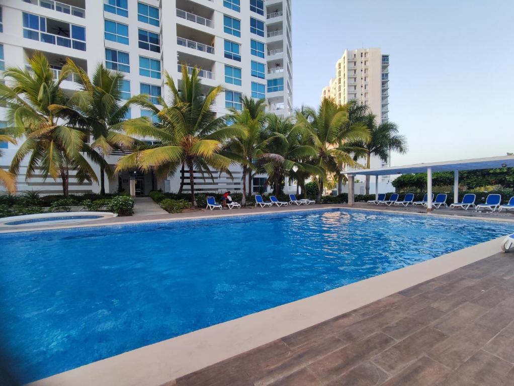 a large swimming pool with palm trees and buildings at Villas de Playa Blanca, Rooftop Vista al Mar in Río Hato