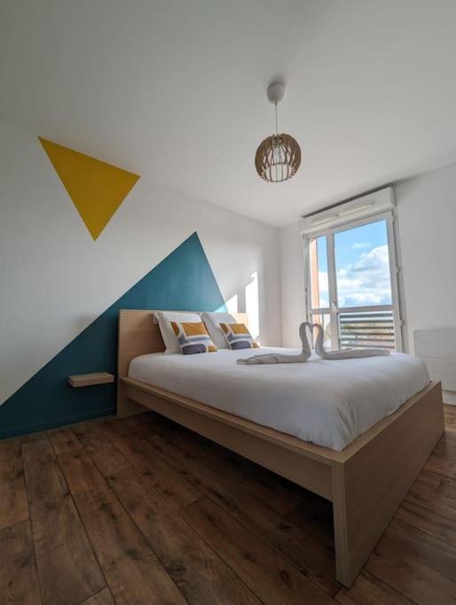 une chambre avec un grand lit et une fenêtre dans l'établissement Disney’s Gallery à 5 minutes de Disneyland Paris, à Montévrain