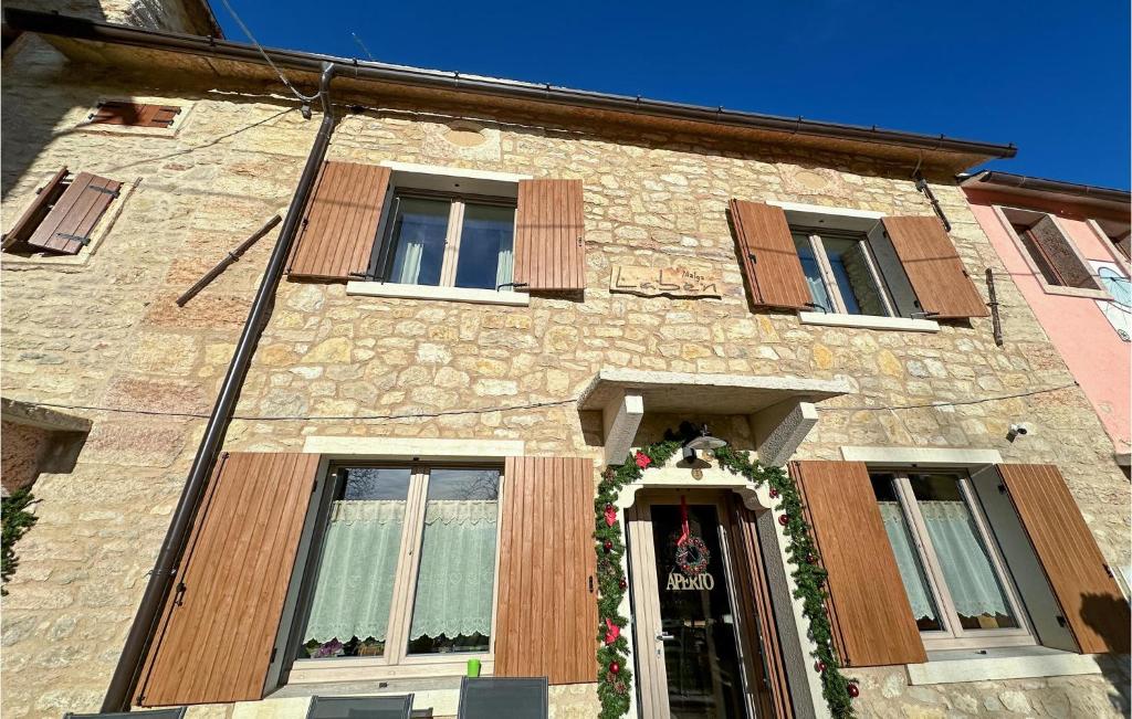 a stone building with a wreath on the door at Gorgeous Apartment In Velo Veronese With House A Panoramic View in Velo Veronese