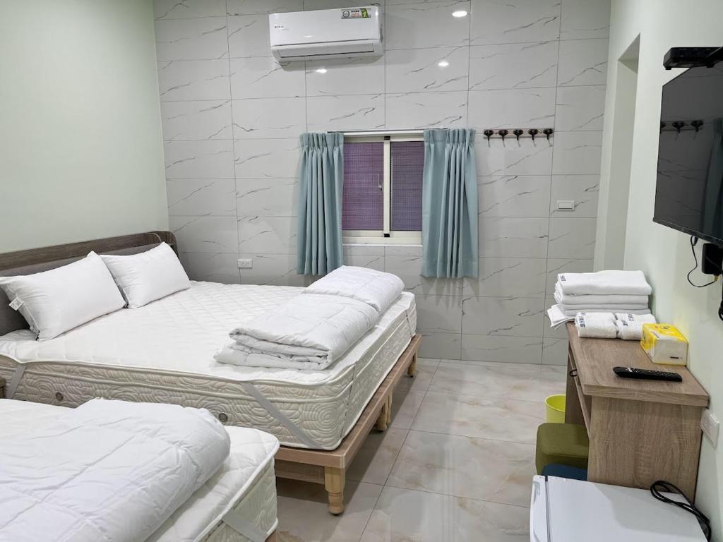 a room with two beds and a television in it at Sky south in Xiaoliuqiu