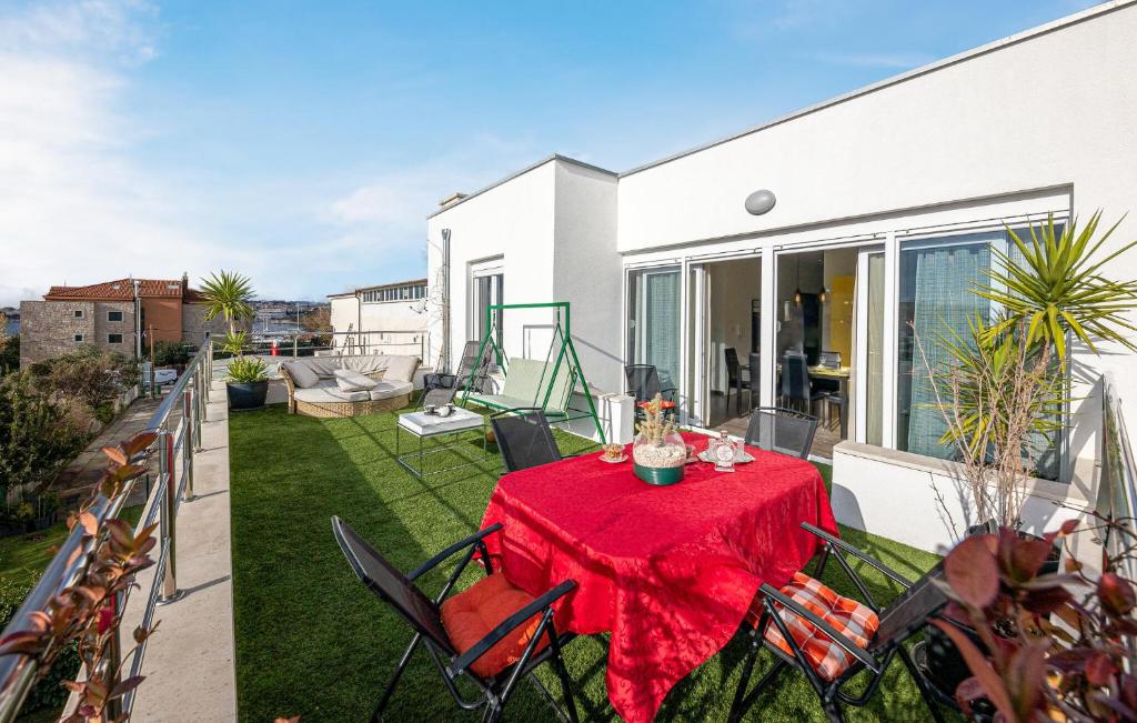 eine Terrasse mit einem Tisch und einem roten Tischtuch in der Unterkunft Nice Home In Podstrana With House Sea View in Podstrana