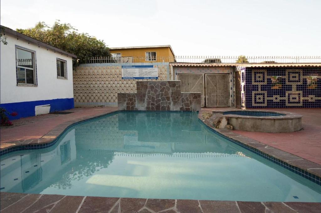 a swimming pool in a yard next to a building at Hacienda Corteza in Rosarito