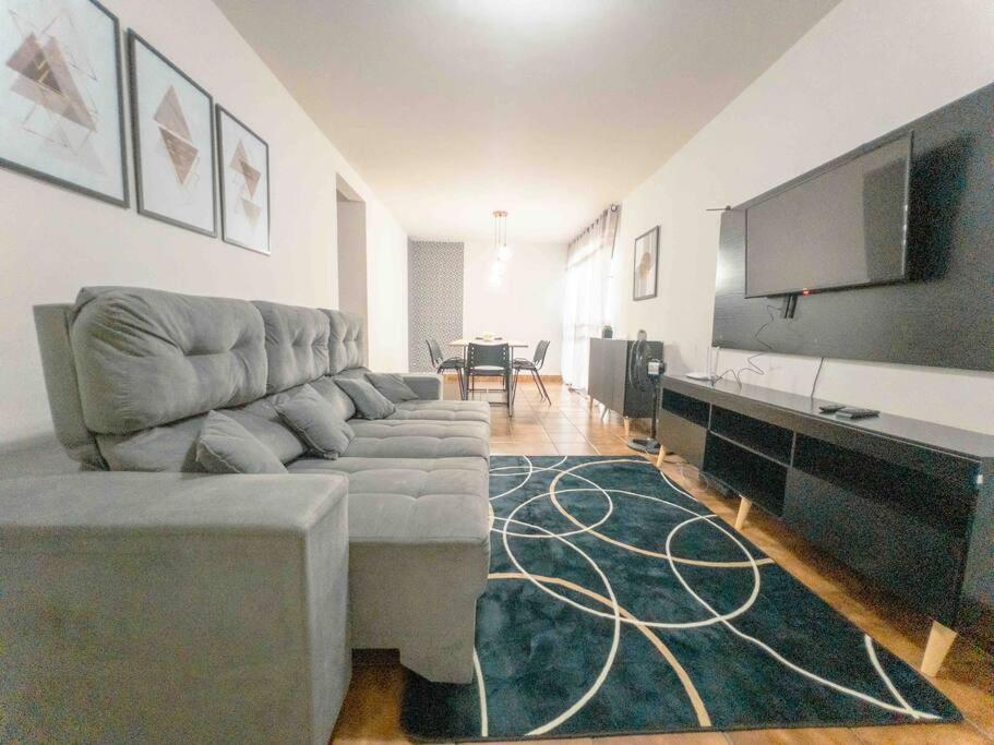 Una sala de estar con un sofá y un televisor de pantalla plana. en Apartamento Smart Centro MC53, en Maringá