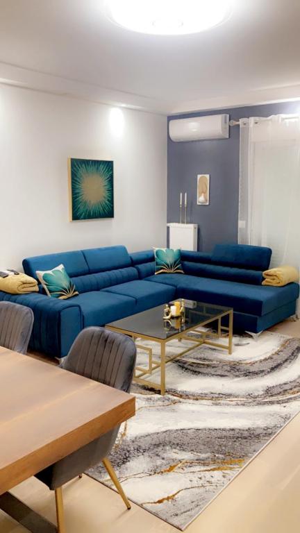 uma sala de estar com um sofá azul e uma mesa em Mi appartement mi maison em Guyancourt