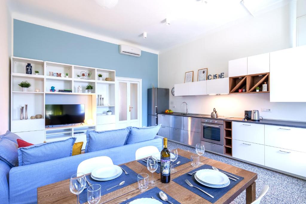 a living room with a blue couch and a table at [Duomo/Navigli] Casa Elegante in zona Tortona in Milan