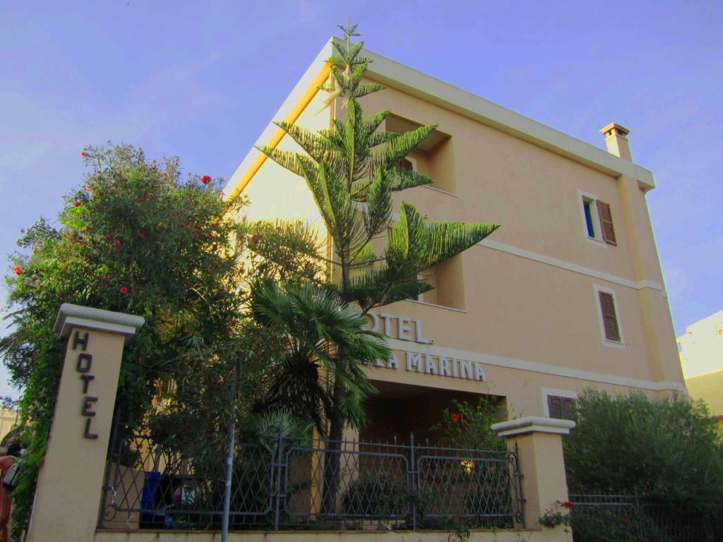 un bâtiment avec un arbre sur son côté dans l'établissement Hotel Villa Marina, à La Maddalena