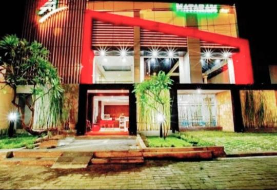 un grand bâtiment avec un rouge et un blanc dans l'établissement Mataram hotel, à Tjakranegara